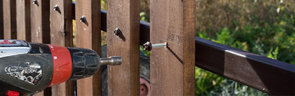 a diyer building a fence with fencing accessories