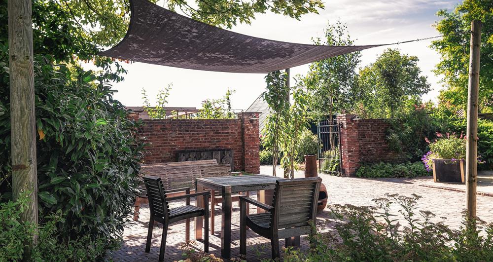 Trendy garden with terrace and overhang, decorated with trendy outdoor furniture and plants