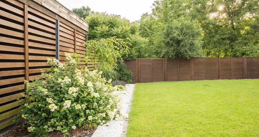 a large garden lawn hidden by slatted fence screens