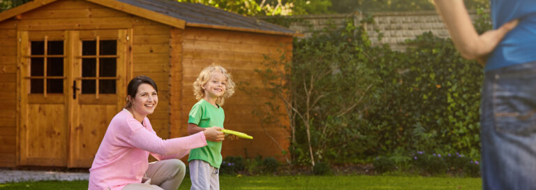 a family who are happy that they have found the best garden shed for their outdoor space