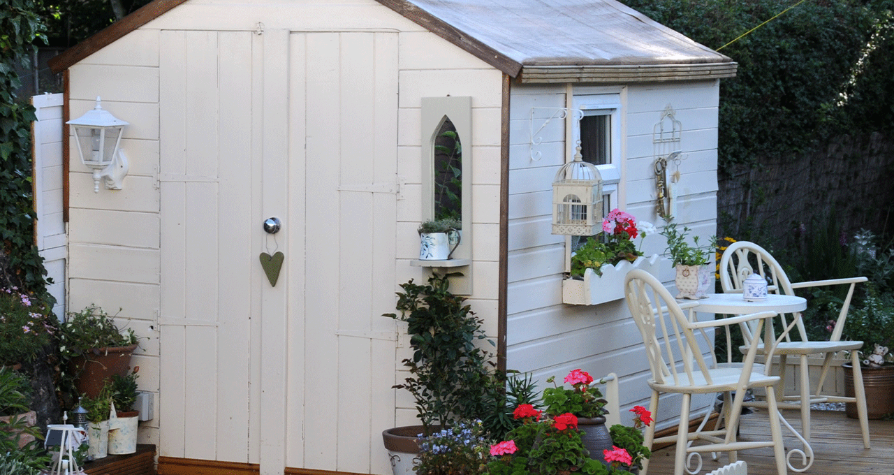 A white shabby chic themed potting shed that has been repainted.