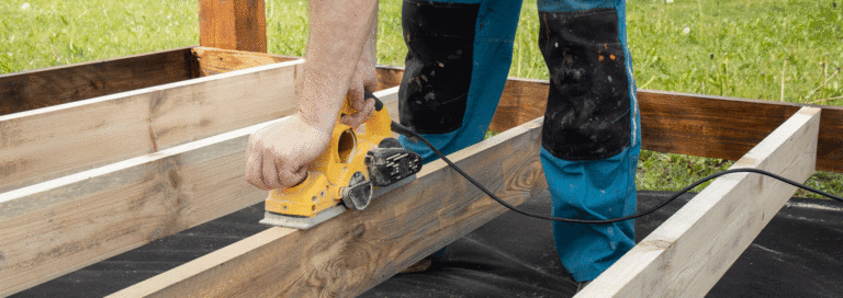 A man using timber for outdoor use in a decking project.